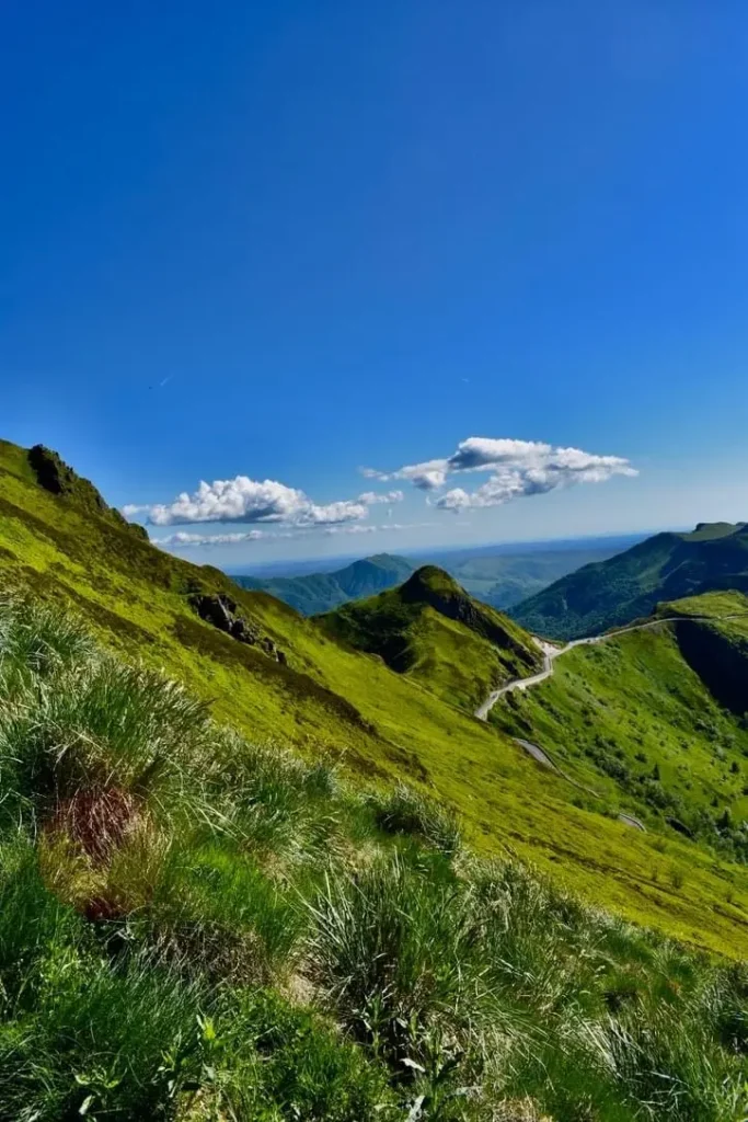 La Grange de L'Abille 7 Puy Mary panorama La Grange de L'Abille Montagnes verdoyantes sous un ciel bleu du Puy-Mary dans le Cantal