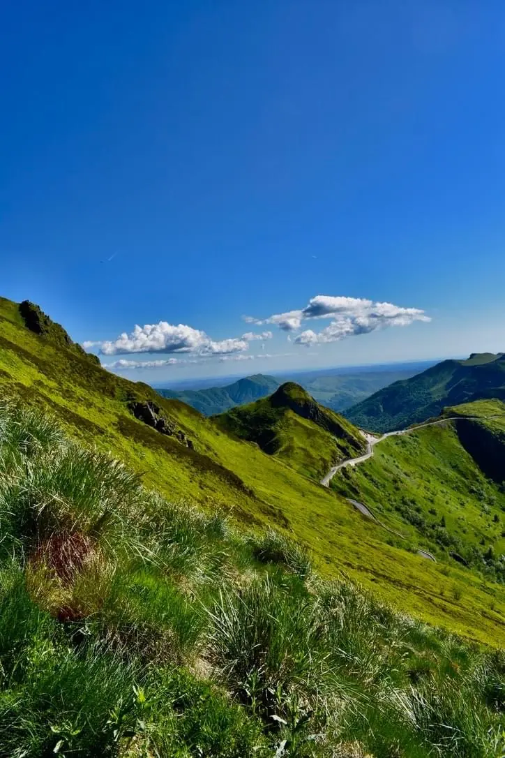 La Grange de L'Abille 5 Puy Mary panorama La Grange de L'Abille Montagnes verdoyantes sous un ciel bleu du Puy-Mary dans le Cantal