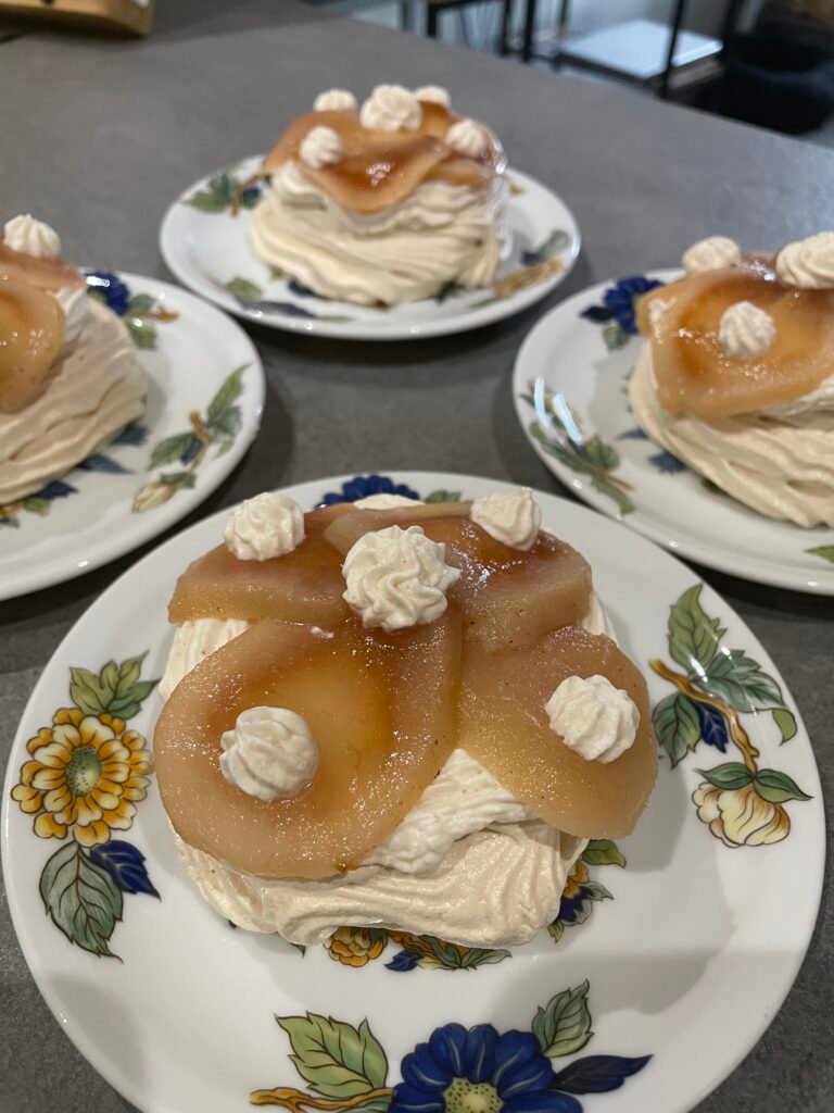 Assiettes fleuries de desserts : meringues garnies de poires pochées et de crème