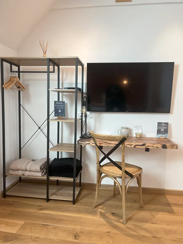 Coin bureau de la chambre Fougère : étagère métallique, bureau en bois brut et télévision murale