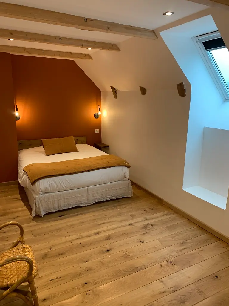 The Fougère room seen from the entrance: bed, terracotta wall and roof window