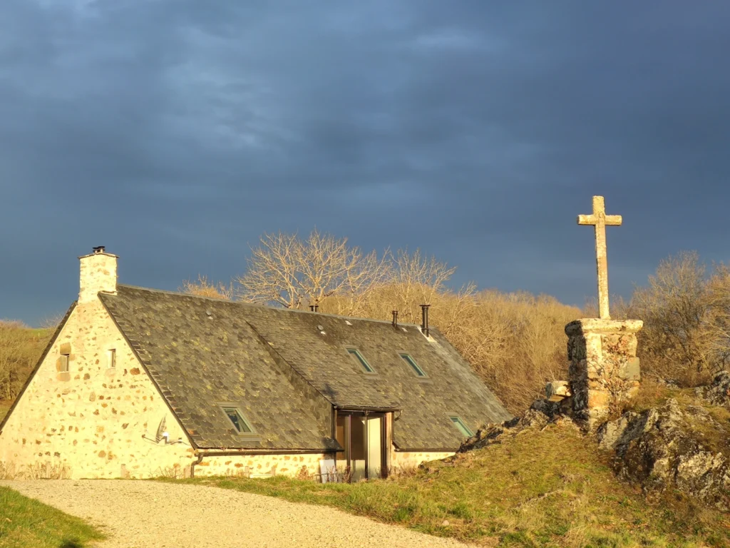 Die Rückseite von La Grange und das Steinkreuz, das über dem Haus wacht, im Abendlicht