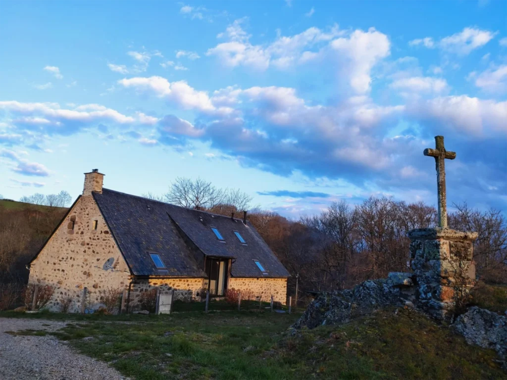 La Grange de L’Abille und das Steinkreuz unter einem Himmel am Ende des Tages